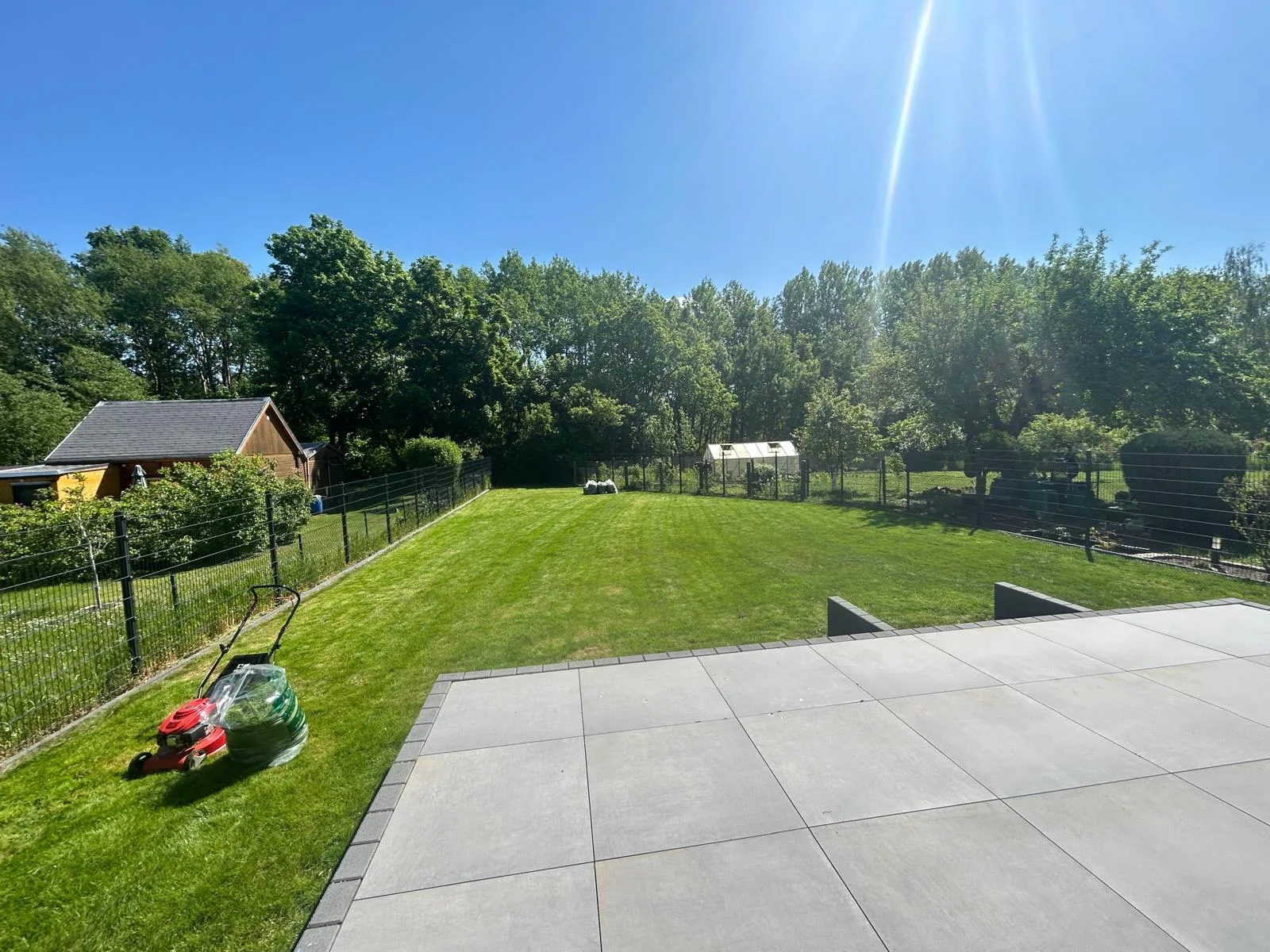 Frisch gemähter Rasen und gepflegter Garten mit Terrasse